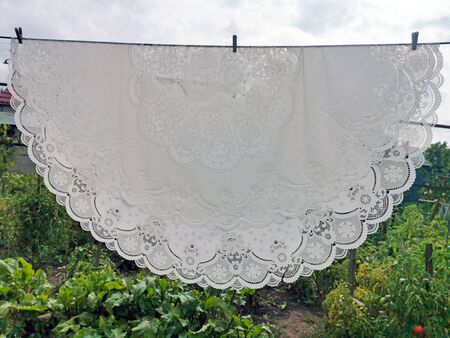 White lace tablecloth is dried on the streetの写真素材
