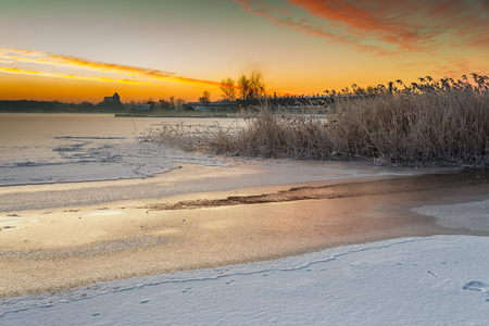 Winter landscape at frozen bay of Puck. Warm light of sunrise early morning. Poland.の写真素材