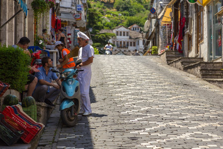 Gjirokaster, Albania- 28 June 2014: People on the main street of historic town Gjirokasteron in Gjirokaster. World Heritage Site by UNESCO. Called the city of a thousand stairs.のeditorial素材
