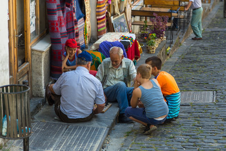Gjirokaster, Albania- 28 June 2014: People on the main street of historic town Gjirokasteron in Gjirokaster. World Heritage Site by UNESCO. Called the city of a thousand stairs.のeditorial素材