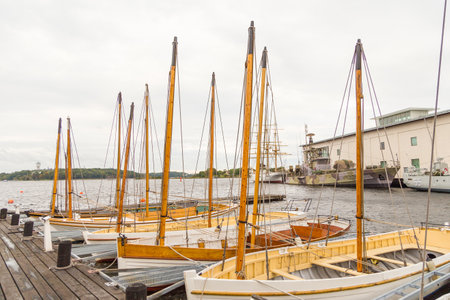 Karlskrona, Sweden - 31 August, 2014: Sailboats moored in the port. Warships, sailing ship and building Marinmuseum in the background.のeditorial素材