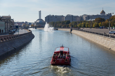 Moscow, Russia- 21 September 2014: Tourist ferry on the Moscow River. Buildings along the shore, Tretyakovskij Bridge and gold dome of the temple.のeditorial素材