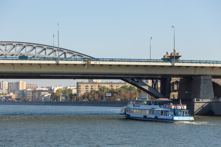 Moscow, Russia- 21 September 2014: Tourist ferry on the Moscow River. Buildings along the shore, Trail Bridge the background.のeditorial素材