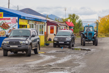 Sokoch, Russia- 27 September 2014: Russian off-road cars and tractor. Parking in front of shops in the village in autumn.のeditorial素材