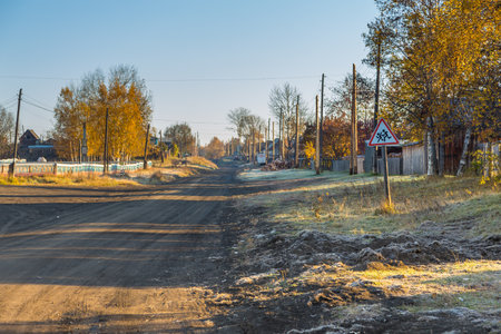 Kozyriewsk, Kamchatka, Russia- 28 September 2014: Main, sandy road in small village in Kamchatka Peninsula. Poor wooden buildings, big car on the road.のeditorial素材