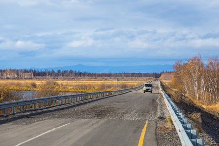 Unnamed Road, Kamchatka Peninsula, Russia- 02 October 2014: UAZ, russian car on a gravel road. Entering the bridge over the Kamchatka River. The beginning of asphalt.のeditorial素材