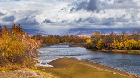 View of the Kamchatka River. Forest in autumn colors, mountain in the background. Kamchatka...