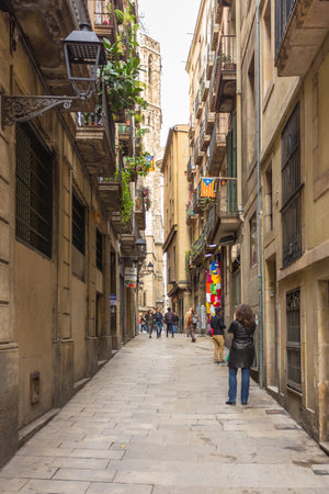 Barcelona, Spain- 09 November 2014: Carrer del Paradis, narrow street at the center of the town. People on the street, shop wit souvenirs, facade of a historic tenement house.のeditorial素材