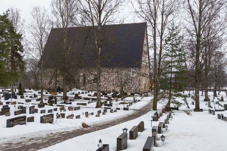 Hollola, Finland- 02 March 2015: View of the medieval, stone Church, Hollolan Kirkko, with cemetery. One of the oldest monuments in Finland. Winter season.のeditorial素材