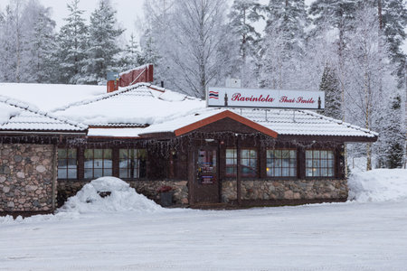 Hollola, Finland- 04 March 2015: Motel Salpakievari, Ravintola Thai Smile in a stone building covered with snow. Forest in the background.のeditorial素材