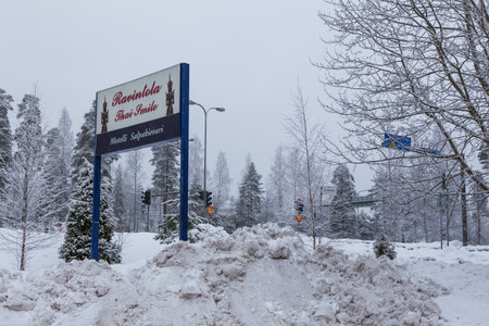 Hollola, Finland- 04 March 2015: Motel, Salpakievari, Ravintola Thai Smile, advertisement covered with snow. Forest and traffic light in the background.のeditorial素材