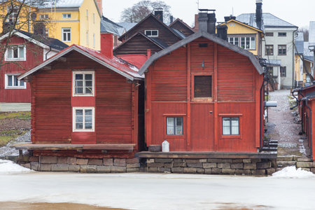 Porvoo, Finland 04 March: 2015: View of the old ocher magazines and historic Old Town, Vanha Porvoo, with medieval, wooden architecture. Frozen Porvoonjoki River in the first plan.のeditorial素材