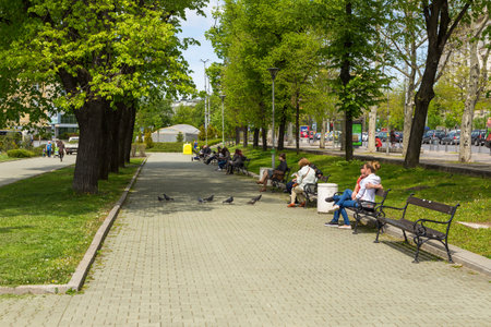 Sofia, Bulgaria- 30 April 2015: Alley in the park in Old City Center. People resting on benches. Tzar Osvoboditel Boulevard in the background.のeditorial素材