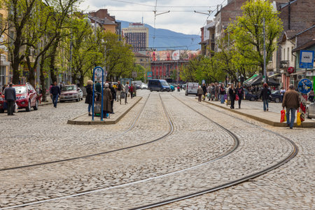 Sofia, Bulgaria- 30 April 2015: Tram tracks on Stefan Stambolov street. Historic tenement houses and modern building. People waiting at the tram stop. Vitosha massif in the background.のeditorial素材