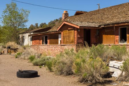 Abandoned, destroyed buildings at 6 road. Damaged tire in front of the house. Ghost town, Inyo...