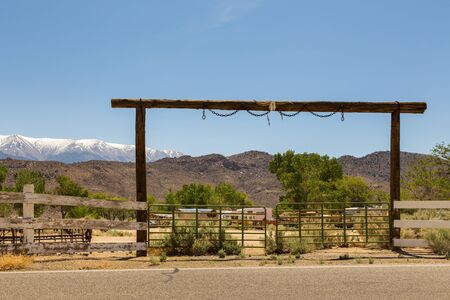 Camping behind a wooden gate. Deer skull on the upper beam. Snow-capped Sierra Nevada mountains in the background, Benton, California, USA.の写真素材