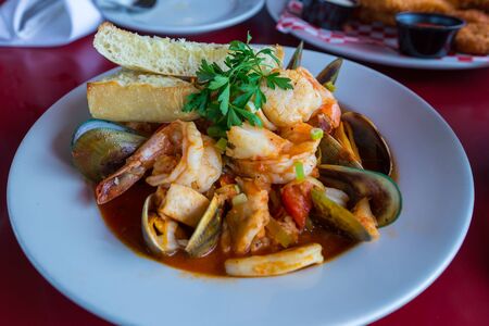 Assorted delicious seafood on the plate. Shrimps, mussels and squid decorated with parsley. Monterey, California, USA.の写真素材
