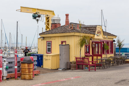 Monterey, California, USA- 09 June 2015: View of the yellow, wooden restaurant building at Municipal Wharf. Yellow crane in the background.のeditorial素材