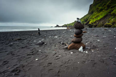 View of the black, volcanic beach in Vik and Myrdal, Iceland. Stone mounds on the beach.の写真素材