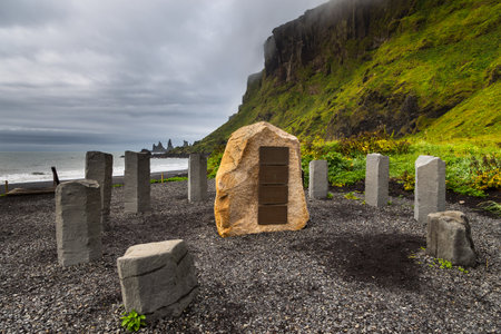 Vik and Myrdal, Iceland - 23 August 2015: Stone circle on the black, volcanic beach. Reynisdrangar rock formation in the background.のeditorial素材