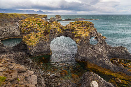 Rocky basalt cliffs on the south coast of the Snaefellsnes peninsula. Gatklettur rock formation. Arnarstapi, Western Iceland.の写真素材