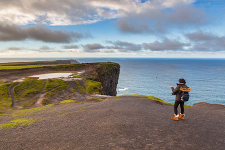 Cliffs of Moher, Burren Way, Ireland- 07 November 2015: People walking and staying at the cliffs of Moher located at the edge of the Burren region in County Clare ,.のeditorial素材