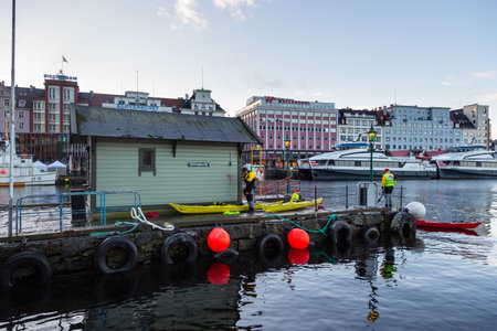 Bergen, Norway- December 12, 2015: Men at the port building, Modern building an ships in the background. Vagen Harbor.のeditorial素材