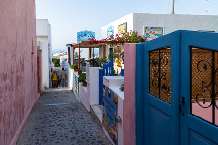 Oia, Santorini Island, Greece- 18 September 2020: A restaurant on a narrow, scenic, cobblestone street in the old town.のeditorial素材