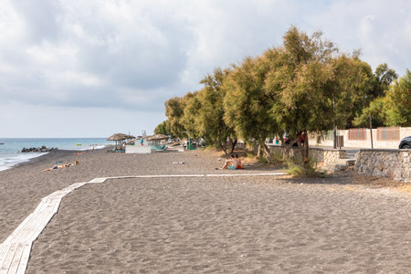 Perissa Beach, Santorini, Greece - 19 September 2020: Top view of Perissa beach on the Greek island of Santorini with sunbeds and umbrellas. Beach is covered with fine black, volcanic sand.のeditorial素材