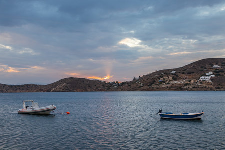 Paralia Gialos, Ios Island, Greece- 19 September 2020: Boat moored in the bay. White traditional...