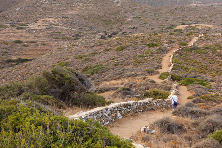 Ios Island, Greece- 20 September 2020: Tourist on the path to the prehistoric tomb of Homer. View of the mountain.のeditorial素材