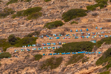 Colorful, wooden beehives on the mountainside in the north of Ios. Greece.