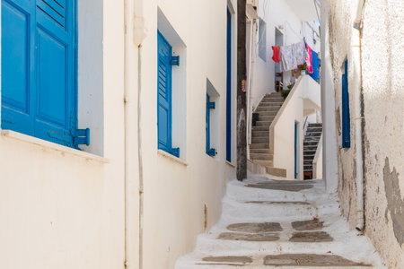 Chora, Ios Island, Greece- 20 September 2020: Narrow street of the old town. Traditional, withe architecture and a stone path with white joints.のeditorial素材