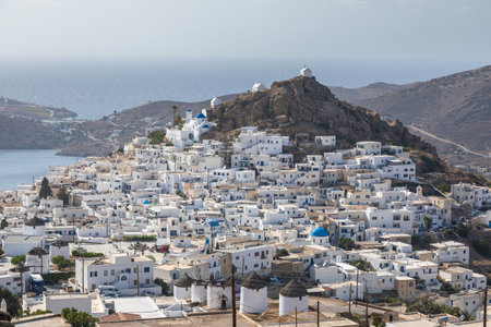Chora, Ios Island, Greece- 20 September 2020: View of the traditional, white, old buildings in Chora harbor from hill. Beautiful summer day.のeditorial素材
