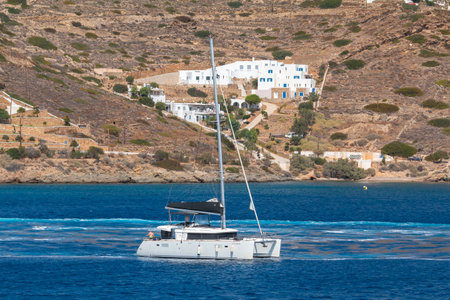 Chora, Ios Island, Greece- 22 September 2020: Catamaran departing from the port of Chora. Hills with White traditional buildings in the background.のeditorial素材