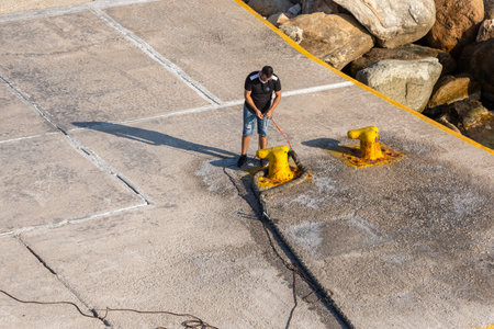 Sikonos, Greece- 23 September 2020: View of the harbor of Sikinos Island. Man tying the rope to the ferry.のeditorial素材