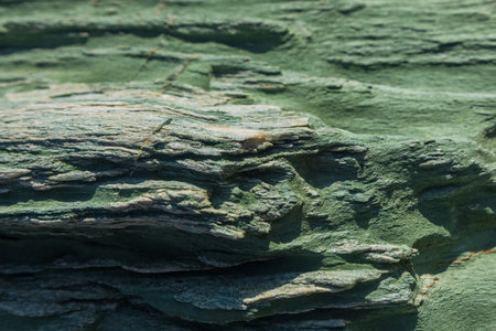 Turquoise green rock, background texture, natural stone off the coast of Folegandros island. Greece.の写真素材