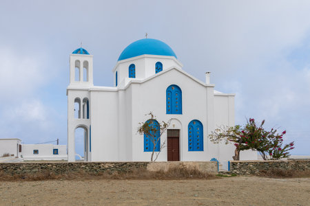 Ano Meria, Folegandros Island, Greece - 24 September 2020: Saint George Church, big building with blue domes and shutters.のeditorial素材