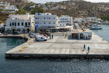 Port on the island of Ios, Greece - 26 September 2020: View of the harbor of Ios Island. People waiting for the ferry. Traditional white building on the hills.のeditorial素材