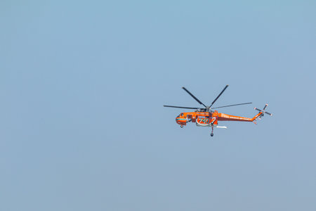 Paros Island, Greece- 26 September 2020: A helicopter of the fire brigade extinguishing a fire off the coast of the Paros island. Sikorsky s-64e skycrane.のeditorial素材