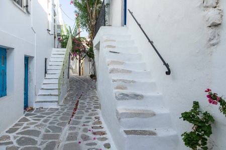 Parikia, Paros Island, Greece - 26 September 2020: Narrow street of the old town. Traditional, withe architecture and a stone path with white joints.のeditorial素材