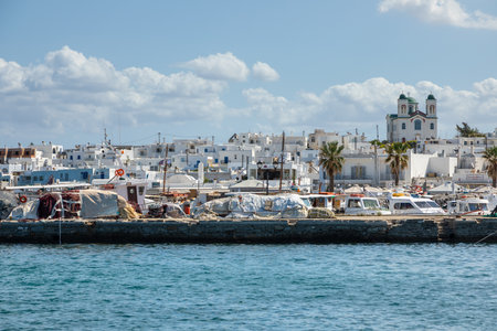 Naoussa, Paros Island, Greece - 27 September 2020: View of the small port town on the island of Paros. White villas on the hill, Church of Naoussa, Kimisis Theotokou in the background.のeditorial素材