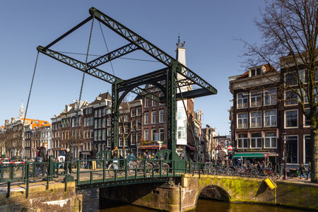 Amsterdam, Netherlands -12 March 2016: Skinny Bridge, Magere Brug over the Amstel canal. Typical dutch houses. City view.のeditorial素材