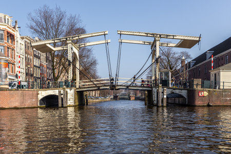 Amsterdam, Netherlands -12 March 2016: Skinny Bridge, Magere Brug over the Amstel canal. Typical dutch houses. City view.のeditorial素材