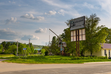 Lozova, Gagazuzia, Republic of Moldova - 02 May 2016: Concrete well casing, water intake point by the roadside. A chapel with a blue cross.のeditorial素材