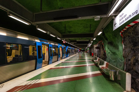 Stockholm, Sweden - June 25, 2016: Modern train on the Kungstradgarden metro station, carved out of the rock. Green walls.のeditorial素材