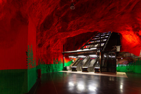 Stockholm, Sweden - June 25, 2016: Escalator in Solna Centrum Station, metro station carved out of the rock. Red walls.のeditorial素材