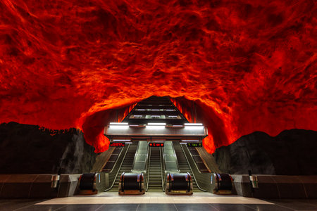 Stockholm, Sweden - June 25, 2016: Escalator in Solna Centrum Station, metro station carved out of the rock. Red walls.のeditorial素材