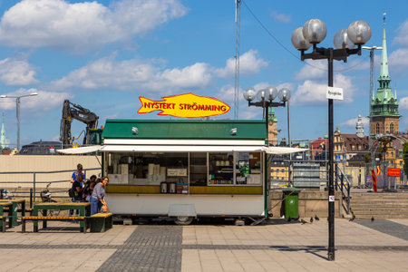 Stockholm, Sweden - June 25, 2016: View of the herring booth street food. The Old Town is one of the largest and best preserved medieval city centers in Europe in the background.のeditorial素材