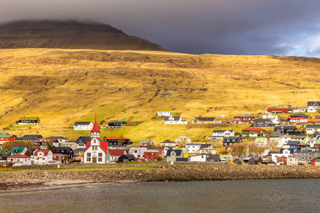 View of the Sandavagur with Sandavags church on Vagar island. A small village situated on the slope of a hill. Faroe Islands.の写真素材